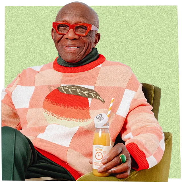 a man wearing a big knitwear jumper and drinking an innocent smoothie